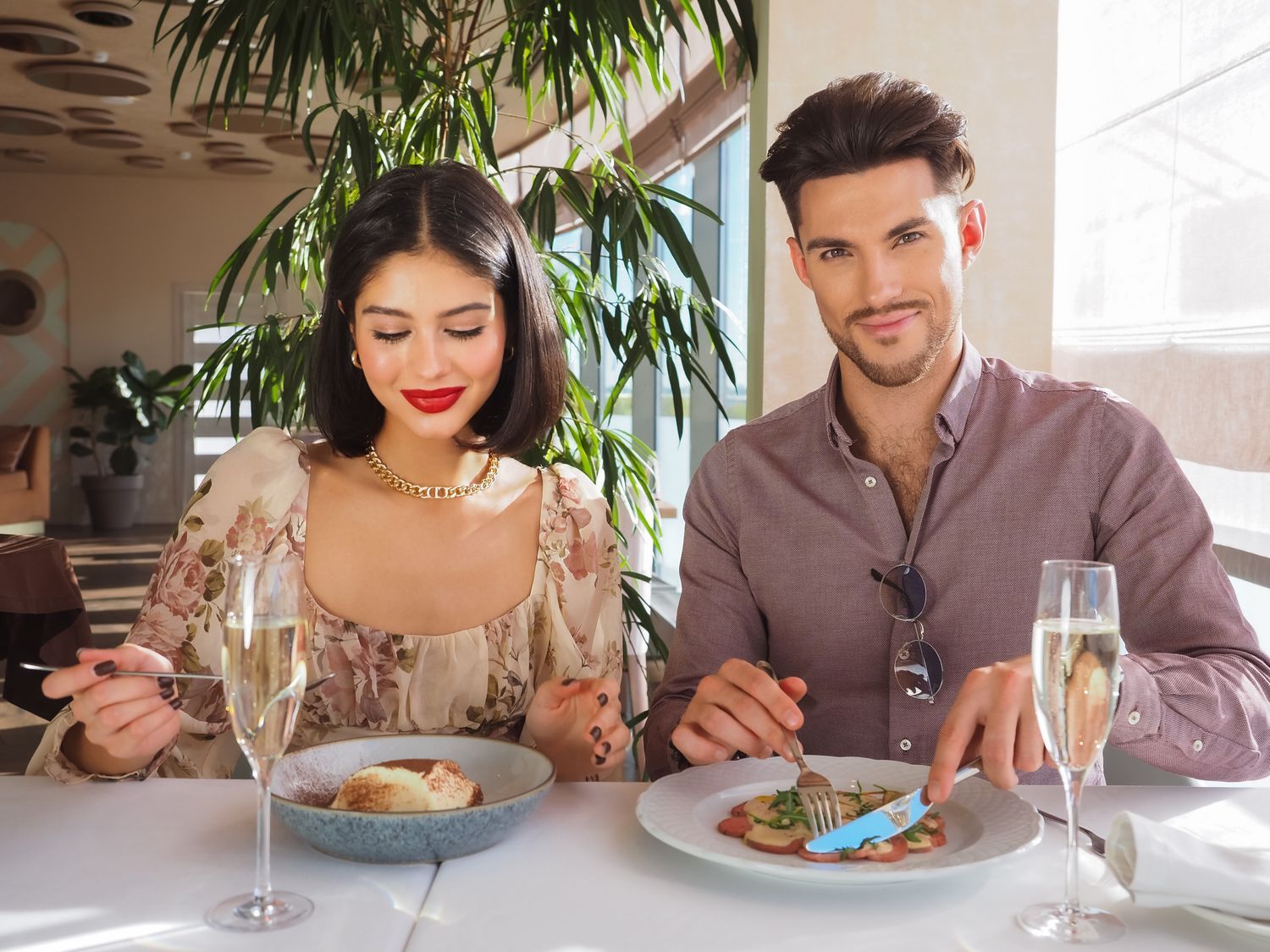 An attractive couple sharing champagne at an upscale restaurant