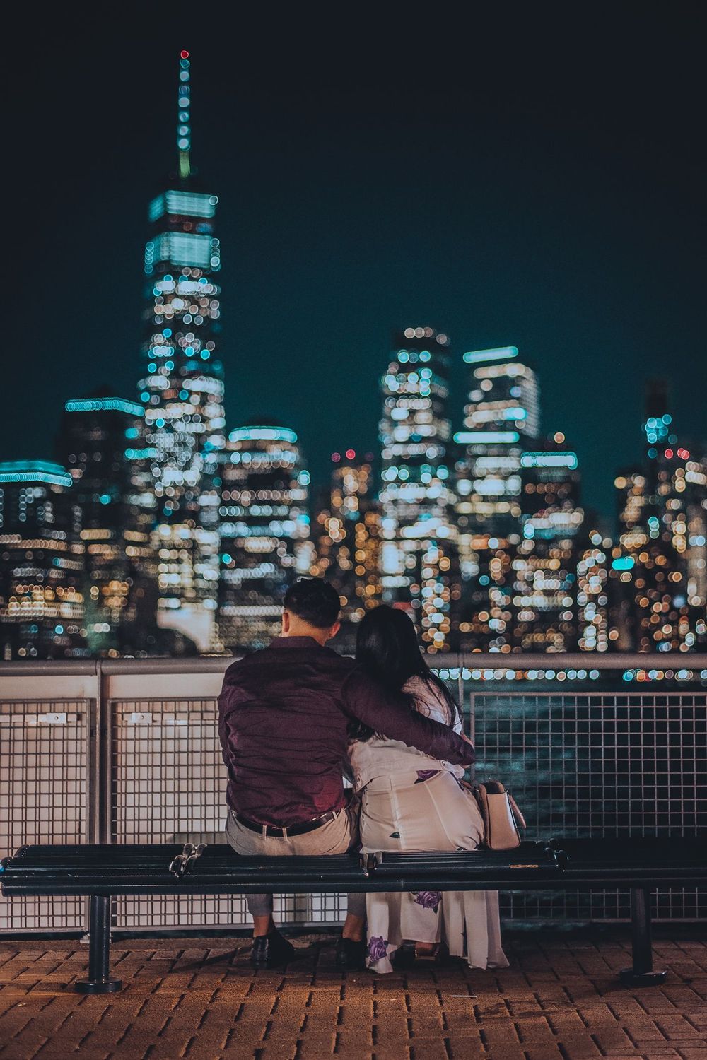 A couple overlooking the city skyline at night